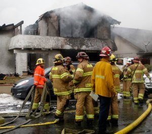 Firefighters suppress a fire at the scene of a deadly plane crash in the residential neighborhood of Yorba Linda, Calif., Sunday, Feb. 3, 2019. The Federal Aviation Administration said a twin-engine Cessna 414A crashed in Yorba Linda shortly after taking off from the Fullerton Municipal Airport.