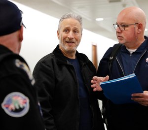Entertainer and activist Jon Stewart, center, speaks with members of the FealGood Foundation as they arrive on Capitol Hill to speak with lawmakers about the compensation fund for victims of 9/11, Monday, Feb. 25, 2019, on Capitol Hill in Washington.