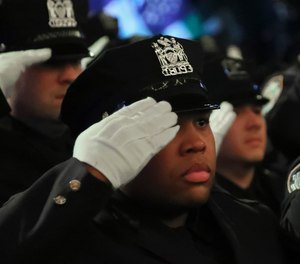 New York City Police Academy graduates salute during the national anthem at their graduation ceremony on Thursday April 18, 2019, in New York.