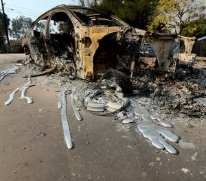 This Nov. 10, 2018, file photo shows molten aluminum that flowed from a car that burned in front of one of at least 20 homes destroyed just on Windermere Drive in the Point Dume area of Malibu, Calif.,