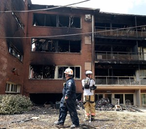 In this Aug. 11, 2016, file photo, emergency personnel view the scene of an apartment building fire in Silver Spring, Md.