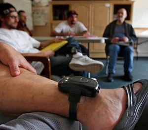 In this photo taken Wednesday, Feb. 20, 2019, a GPS bracelet is seen on the ankle of an inmate attending a discussion about living in sobriety at the Male Community Re-entry Program in Oroville, Calif.