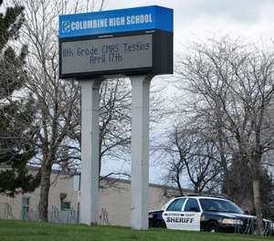 In this April 17, 2019, file photo, a patrol car is parked in front of Columbine High School in Littleton, Colo., where two student killed 12 classmates and a teacher in 1999.