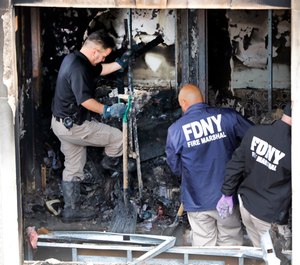 Fire marshals sift through a burned out apartment in New York's Harlem neighborhood, Wednesday, May 8, 2019. Six people, including four children, were killed Wednesday when an overnight fire ravaged an apartment in a city-owned Harlem building. (AP Photo/Richard Drew)