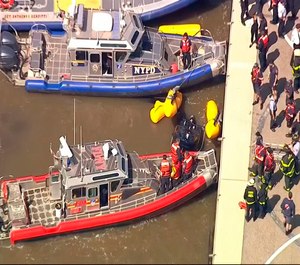 In this image made from video provided by WABC-TV, harbor units from the New York City police and fire departments work to secure a helicopter to the dock after it crashed in the Hudson River, Wednesday, May 15, 2019 in New York. WABC reports that the pilot was ok and that there were no passengers on the aircraft. (WABC-TV via AP)