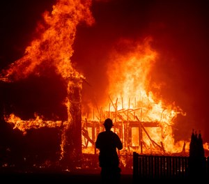 In this Nov. 8, 2018 file photo a home burns as the Camp Fire rages through Paradise, Calif. California fire authorities say that Pacific Gas and Electric equipment was responsible for the deadliest and most destructive wildfire in state history. Cal Fire said in a press release issued Wednesday, May 15, 2019, that electrical transmission lines in the Pulga area sparked the Nov. 8 fire that wiped out most of the town of Paradise and killed 85 people. (AP Photo/Noah Berger,File)