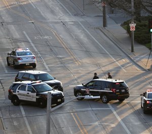 In this Wednesday, May 15, 2019 photo, authorities investigate the scene of a shooting at the Valley Transit Center in Appleton, Wis. A firefighter responding to a medical emergency was killed in the shooting at a Wisconsin bus station that left several others injured, officials said.