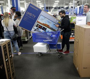 People wait in line to buy televisions as they shop during an early Black Friday sale at a Best Buy on Thanksgiving Day 2018 in Overland Park, Kan.