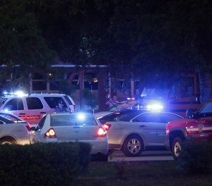 Emergency vehicles fill the parking lot at the Princess Anne Middle School in Virginia Beach, Va, on Friday, May 31, 2019. A longtime city employee opened fire at a municipal building in Virginia Beach on Friday, killing 11 people before police shot and killed him, authorities said. Six other people were wounded in the shooting, including a police officer whose bulletproof vest saved his life, said Virginia Beach Police Chief James Cervera. (AP Photo/Vicki Cronis-Nohe)