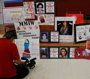 In this June 14, 2019, file photo, a photographer videos signs in memory of missing and murdered indigenous women following a march to call for justice for missing and murdered indigenous women at the Cheyenne and Arapaho Tribes of Oklahoma in Concho, Okla.