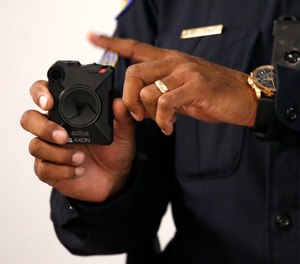Phoenix Police Department Sgt. Kevin Johnson demonstrates the new Axon Body 2 body camera to fellow officers as another precinct gets their cameras assigned to them Wednesday, July 3, 2019, in Phoenix.