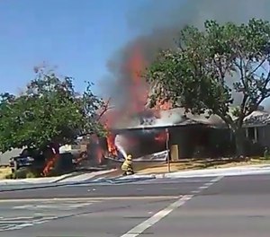 In this image taken from video provided by Ben Hood, a firefighter works to extinguish a fire following an earthquake in Ridgecrest, Calif.
