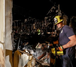 A firefighter looks over a home that burned after a earthquake in Ridgecrest, Calif.