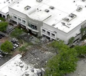 This image taken from video provided by WPLG shows debris covering the parking lot of a shopping center after an explosion on in Plantation, Fla. The explosion happened Saturday morning at the shopping center, west of Fort Lauderdale in Broward County. The blast sent large pieces of debris about 100 yards (about 91 meters) across the street. (WPLG via AP)