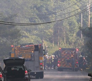 Police close off a smoke filled road as rescue workers respond to a plane that crash into a house in Union Vale, N.Y. The Federal Aviation Administration says three people were on the plane.