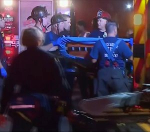 An emergency crew carries stretchers for injured persons after a light rail train was derailed in Sacramento, Calif.
