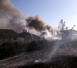 A blaze that started as a grass fire spread to several buildings in northeast Portland. (Photo/Beth Nakamura, The Oregonian via AP)