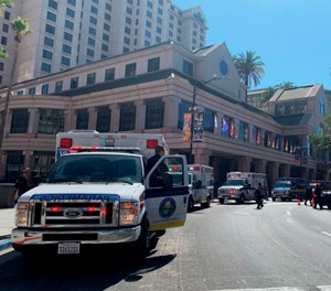 Fire crews gather on Market Street outside the Hotel Fairmont in downtown San Jose, Calif., after a report of a chemical odor. Authorities say at least one woman has died and several people have been sickened in a hazmat incident at the Northern California hotel. (Nico Savidge/San Jose Mercury News via AP)
