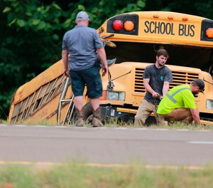 Wrecker crews work on a Benton County School bus that was involved in wreck along U.S. Highway 72 that resulted in the death of the driver and sent several students to the hospital.