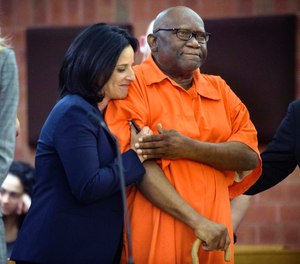 FILE - In this June 8, 2017 file photo, Innocence Project lawyer Vanessa Potkin, left, hugs Alfred Swinton, in Superior Court in Hartford, Conn. Swinton served almost two decades in prison for the 1991 killing of Carla Terry before he was cleared based on new DNA evidence. Several states have moved to toughen regulations on the use of jailhouse informants. Advocates said Swinton's erroneous conviction was based in part on the testimony of lying inmates. (Mark Mirko/Hartford Courant via AP, Pool, File)