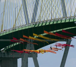Greenpeace USA protesters dangle from the Fred Hartman Bridge. (Photo/Yi-Chin Lee, Houston Chronicle via AP)