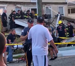 One of the first responders talks to an onlooker, as others work the scene of the structural collapse.