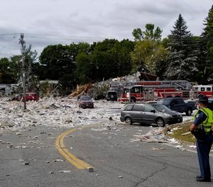 A police officer stands guard at the scene of a deadly propane explosion which leveled new construction in Farmington, Maine.