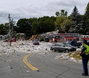 A police officer stands guard at the scene of a deadly propane explosion which leveled new construction in Farmington, Maine.
