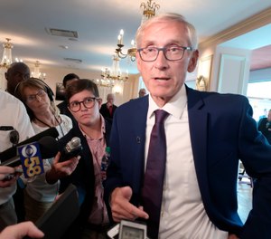 FILE - In this Sept. 24, 2019, file photo, Wisconsin Gov. Tony Evers speaks with reporters at an event in Madison, Wis. Evers plans to announce four pardons on Monday, the first issued by a Wisconsin governor in nearly nine years. Evers revived the Pardons Board this summer after his predecessor, Scott Walker, refused to issue any pardons during his eight years as governor. (AP Photo/Scott Bauer)