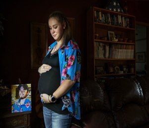 Krista Johnston stands next to a photo of her husband, Sgt. James Johnston, who was killed in Afghanistan in June, while pregnant with their first child. (AP Photo/David Goldman)