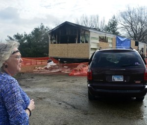 Marie Chockley, a resident of the Timberline Trailer Court, surveys the damage that was caused by the fire that killed five residents in a mobile home. (Kevin Barlow/The Pantagraph via AP)