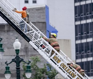 A rescued worker, left, and a firefighter look back at the damaged building after a large portion of a hotel under construction suddenly collapsed in New Orleans.
