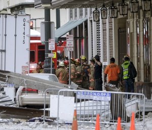 Construction workers are helped by emergency personnel after a large portion of a hotel under construction suddenly collapsed in New Orleans. (Scott Threlkeld/The Advocate via AP)