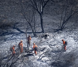 Firefighters put out hot spots in the Porter Ranch area of Los Angeles on Saturday, Oct. 12. (Mindy Schauer/The Orange County Register via AP)