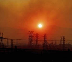 Smoke from a wildfire called the Saddle Ridge Fire hangs above power lines as the sun rises in Newhall, Calif. (AP Photo/Noah Berger)