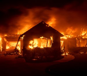 In this Oct. 31, 2019 file photo flames from the Hillside Fire consume a home in San Bernardino, Calif. President Donald Trump on Sunday, Nov. 3 threatened to cut U.S. funding to California for aid during wildfires that have burned across the state during dry winds this fall. (AP Photo/Noah Berger,File)