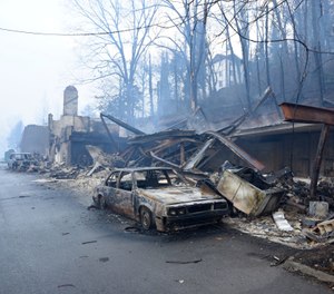 In this Nov. 29, 2016, file photo, a structure and vehicle are damaged from the wildfires around Gatlinburg, Tenn. More than 40 insurance companies are suing the federal government over its handling of a 2016 Tennessee wildfire that killed 14 people and destroyed or damaged more than 2,500 buildings in Sevier County. (Photo/Michael Patrick, Knoxville News Sentinel via AP, File)