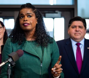 Illinois Gov. J.B. Pritzker looks on as Cook County State's Attorney Kim Foxx speaks during a press conference in Chicago after Foxx filed motions to vacate more than 1,000 low-level cannabis convictions, Wednesday, Dec. 11, 2019. (Ashlee Rezin Garcia/Chicago Sun-Times via AP)
