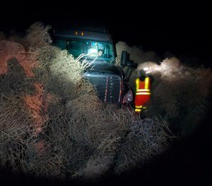 In this image taken Tuesday evening, Dec. 31, 2019, and provided by the Washington State Patrol, a vehicle is trapped by a pile of tumbleweeds along State Route 240 near Richland, Wash. (Trooper Chris Thorson/Washington State Patrol via AP)