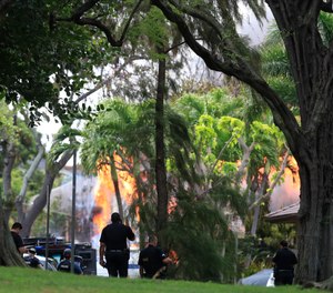 Honolulu police watch a house fire after a shooting and domestic incident at a residence on Hibiscus Road near Diamond Head on Sunday, Jan. 19, 2020, in Honolulu. Witnesses say at least two Honolulu police officers were shot and two civilians were injured. Moments after the shooting, the house was set on fire, possibly by the suspect. (Photo/Jamm Aquino, Honolulu Star-Advertiser via AP)