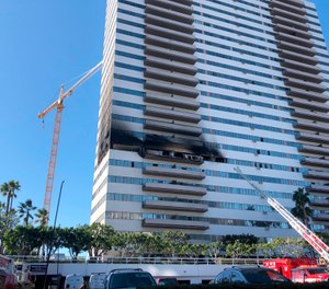 A Los Angeles Fire Department ladder stands at the side of a 25-story high-rise apartment building where a fire broke out on a sixth-floor balcony and sent choking smoke billowing through the upper levels in West Los Angeles Wednesday, Jan. 29, 2020. (AP Photo/Stafanie Dazio)