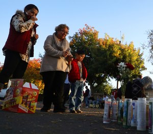 In this Nov. 24, 2019, file photo, community members gather at a memorial site in the parking lot of Searles Elementary School in Union City, Calif., after two minors were shot and killed in the parking lot the day before.