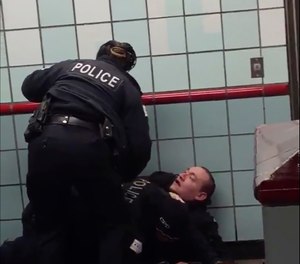 This Friday, Feb. 28, 2020 image from cellphone video shows the officers trying to apprehend the suspect inside a downtown Chicago train station. (Michael McDunnah via AP)