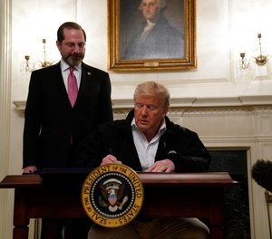 President Donald Trump signs an $8.3 billion bill to fight the coronavirus outbreak in the U.S., Friday, March 6, 2020 at the White House in Washington, as Department of Health and Human Services Secretary Alex Azar, looks on. The legislation provides federal public health agencies with money for vaccines, tests and potential treatments and helps state and local governments prepare and respond to the threat.