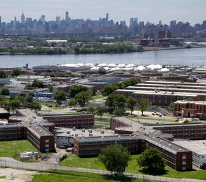 In a June 20, 2014, file photo, the Rikers Island jail complex stands in New York with the Manhattan skyline in the background. The nation’s jails and prisons are on high alert about the prospect of the new coronavirus spreading through their vast inmate populations.