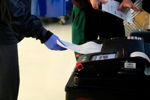 Voters cast their ballots during early voting in Chicago while wearing protective gloves. Image: AP Photo/Noreen Nasir