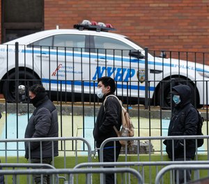 Patients wearing personal protective equipment stand on line while maintaining social distancing before entering a COVID-19 testing site at Elmhurst Hospital Center, Wednesday, March 25, 2020, in New York. Gov. Police have stepped up efforts to pressure New Yorkers to practice social distancing at the epicenter of the crisis. It's part of a global challenge that law enforcement and health officials say is critical to containing the coronavirus.