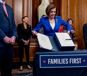 House Speaker Nancy Pelosi lifts the Coronavirus Aid, Relief, and Economic Security (CARES) Act after signing it on Capitol Hill, Friday, March 27, 2020, in Washington.