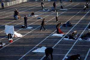 People prepare to sleep in areas marked by painted boxes on the ground of a parking lot at a makeshift camp for the homeless Monday, March 30, 2020, in Las Vegas. Image: AP Photo/John Locher