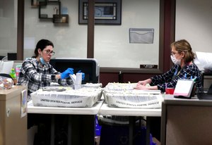 From left Katherine Katsekes, and Diane Scott, both paid volunteers, help sort absentee ballots by ward to be opened on election day at Brookfield City Hall, Tuesday, March 31, 2020. Image: Rick Wood/Milwaukee Journal-Sentinel via AP